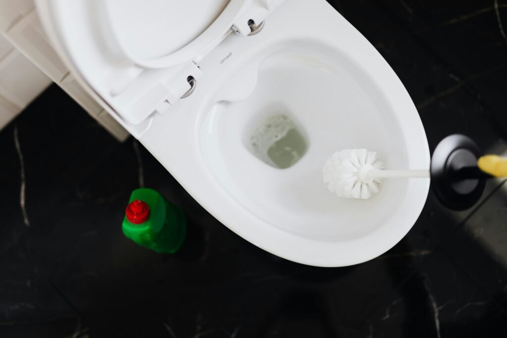 pexels-photo-4239088-4239088 From above crop anonymous person in yellow gloves cleaning toilet bowl with toilet brush and liquid detergent in green plastic bottle
