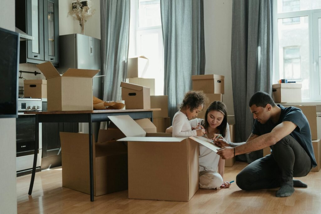 pexels-photo-4569340-4569340 A family unpacks moving boxes in their new home kitchen, creating a cozy atmosphere.